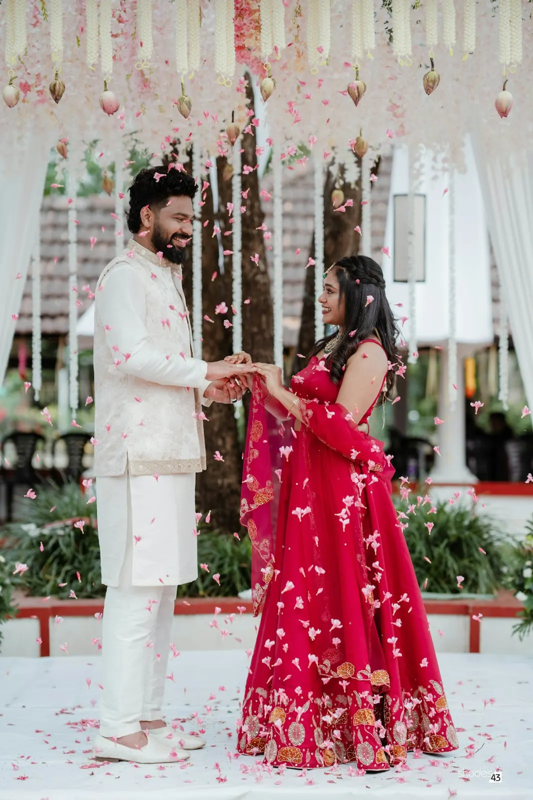 Candid moment of a couple exchanging garlands at their wedding